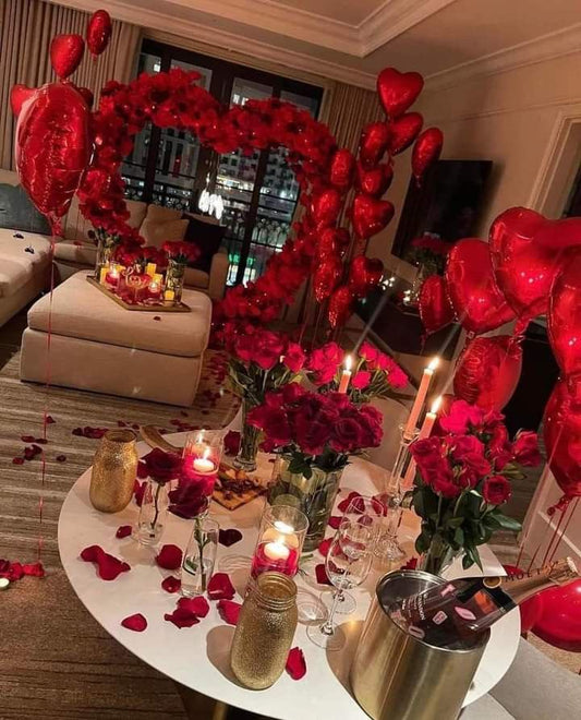 Red Heart-Shaped Foil Balloons, Artificial Red Petals, Artificial Heart-Shaped Flower Arrangement, Rose Flowers in Glass vase and White Candles in Small Glass Cylinder - Proposal Perfect for special occasions
