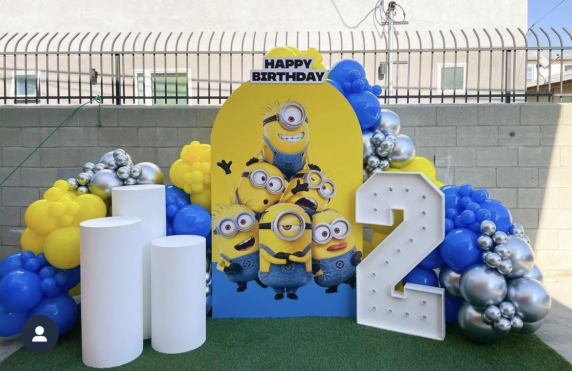 Customizable KT Board Backdrop with Balloon Yellow, Blue and Silver Decor and LED Marquee ‘2’ Number and 3 White Cake Stand Setup Minions-Themed - Perfect for special occasions