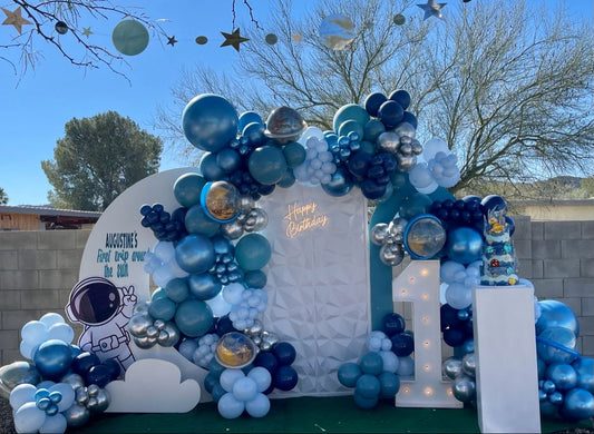 Full Set Customizable Board Backdrop with Balloon Blue with Silver Stars and Moon, Astronaut and Rocket Accents and LED Marquee Number ‘1’, LED Acrylic ‘Happy Birthday’ Lights and White Cake Stand Setup - Galaxy-Themed Perfect for special occasions
