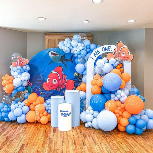 Customizable Board Backdrop with Balloons Blue, Clear and Orange with Nemo Characters and White Cake Stand - Nemo-Themed Perfect for special occasions