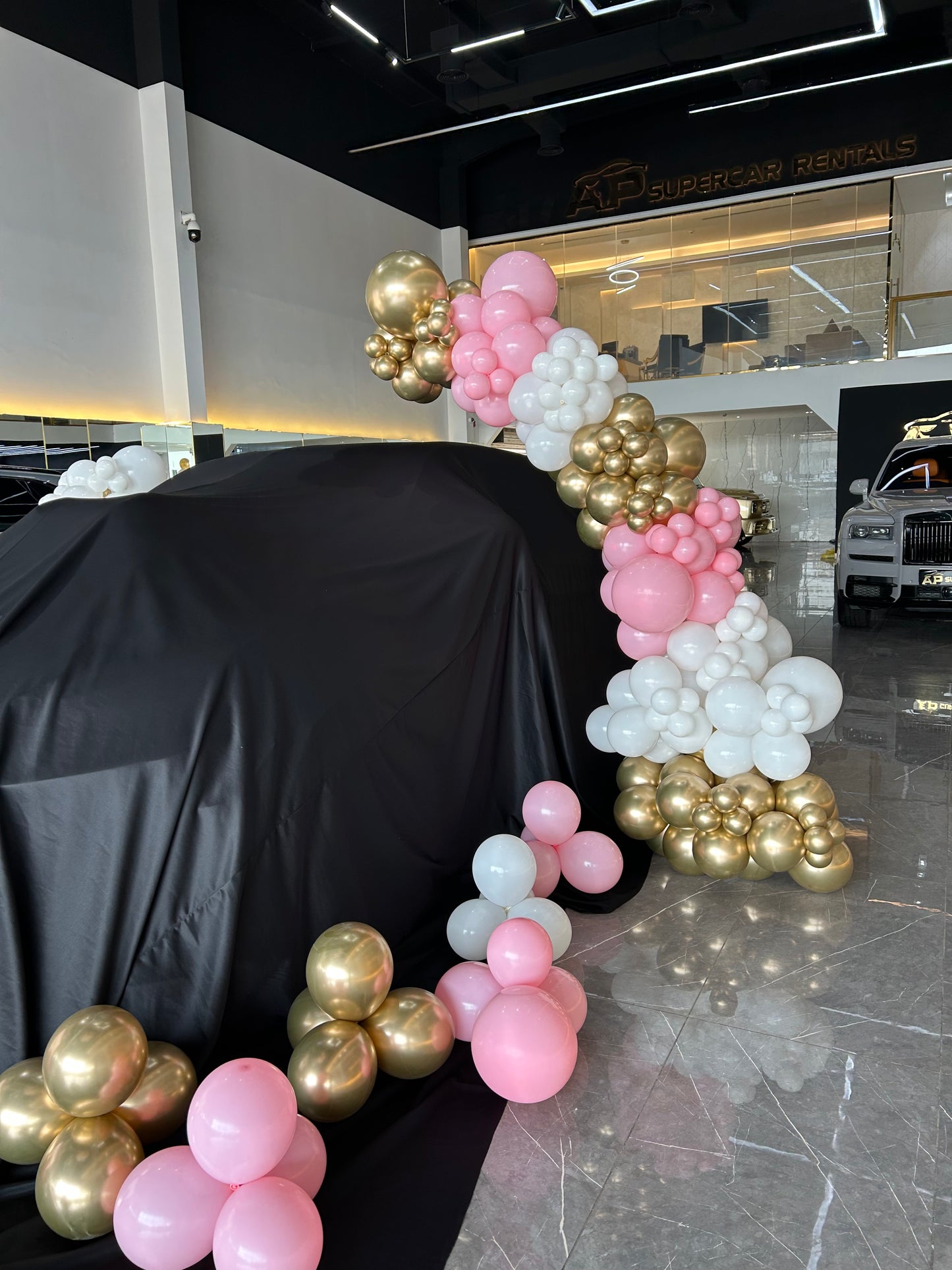 Car Surprise Balloon Design Light Gold, White and Pink with Personalised Helium, Helium Latex Bunch, Red Carpet and Bouquet Fresh Flower Accents – Perfect for Any Sleek and Elegant Celebrations
