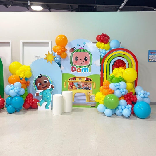 Customizable Board Backdrop with Balloon Blue, Yellow, Orange, Green and Red with JJ Character Standee and White Cake Stand - Cocomelon-Themed Perfect for special occasions