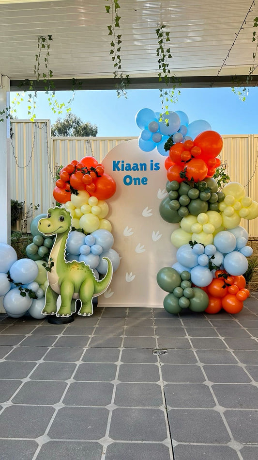 Customizable Board Backdrop with Balloon Orange, Blue, Yellow and Green with Artificial Leaves and Dinosaur Standee - Dinosaur-Themed Perfect for special occasion