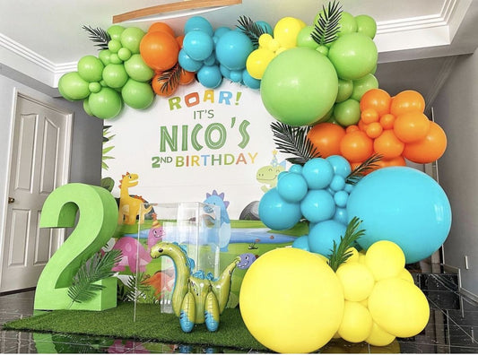 Customizable Board Backdrop with Balloon Green, Orange, Blue and Yellow with Artificial Leaves, Marquee Number’2’, Acrylic Cake Stand and Dinosaur Balloon Standee - Dinosaur-Themed Perfect for special occasion