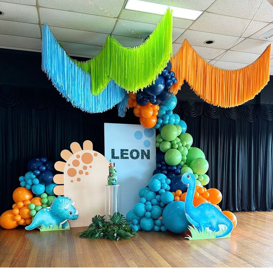 Customizable Board Backdrop with Balloon Turquoise, Blue, Orange and Green with Acrylic Cake Stand, Dinosaur Balloon Standee, Artificial Leaves and Blue, Green and Orange Streamers - Dinosaur-Themed Perfect for special occasion